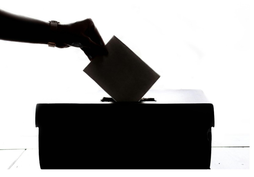 Silhouette of hand putting ballot into ballot box